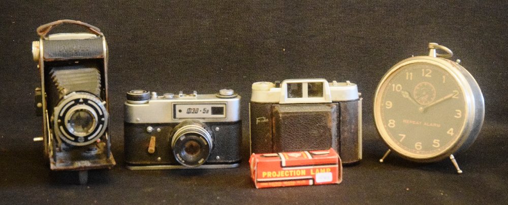 3 Old photographic cameras,  alarm clock and projection lamp