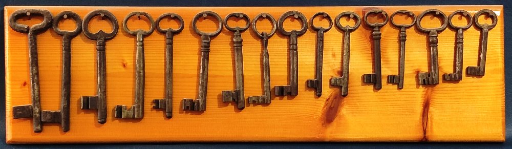 16 Old keys, 9.5cm - 18cm, on wood panel