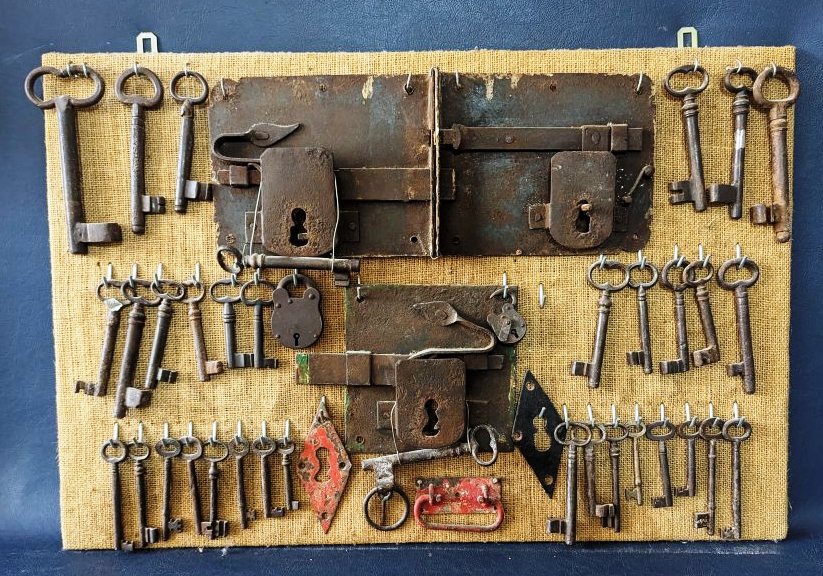 33 Iron old keys and 3 large locks set on display board